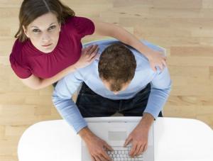 High angle view of a young man using a laptop with a young woman looking up